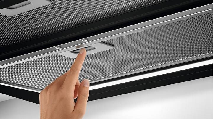 Hand inserts filter in cooker hood